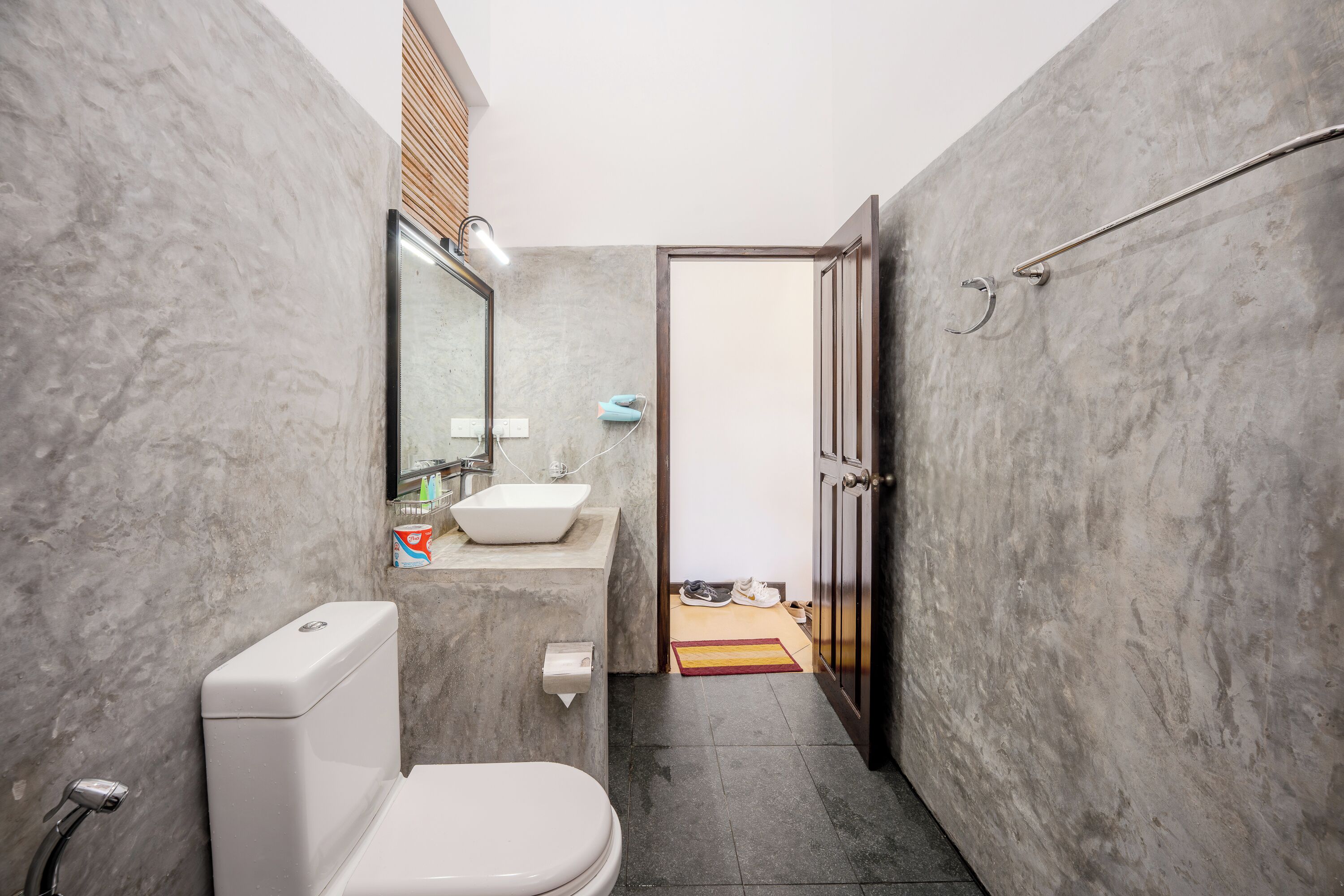A compact bathroom with a toilet, sink, and shower area.