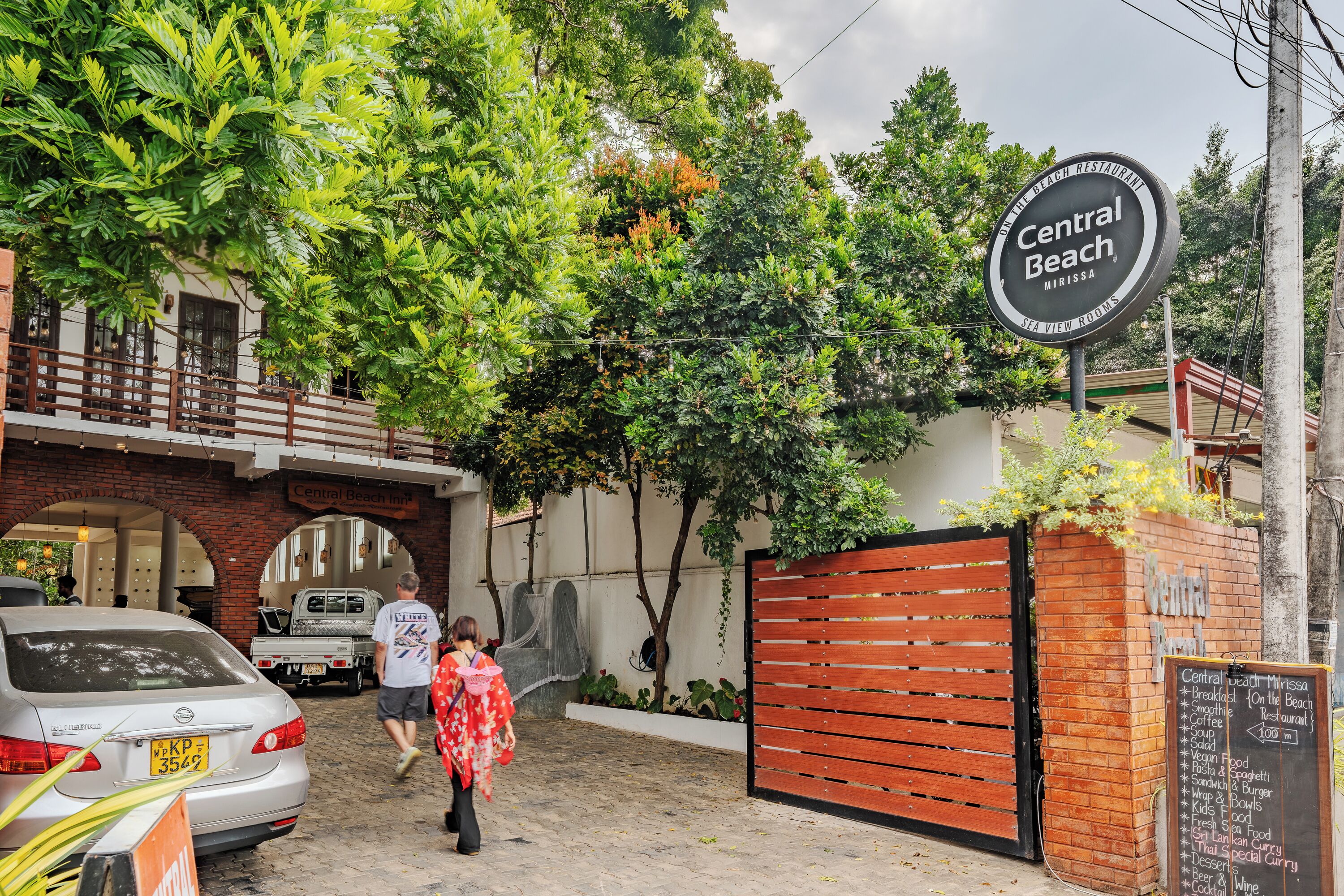 A restaurant named Central Beach with a signboard, brick walls, and a gated entrance.