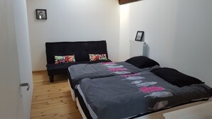 A bedroom with a bed, a bench, and a radiator.