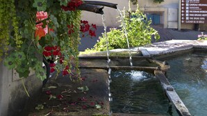 Ein traditionelles Gebäude mit einem Wasserelement, darunter ein Brunnen und ein kleiner Teich.