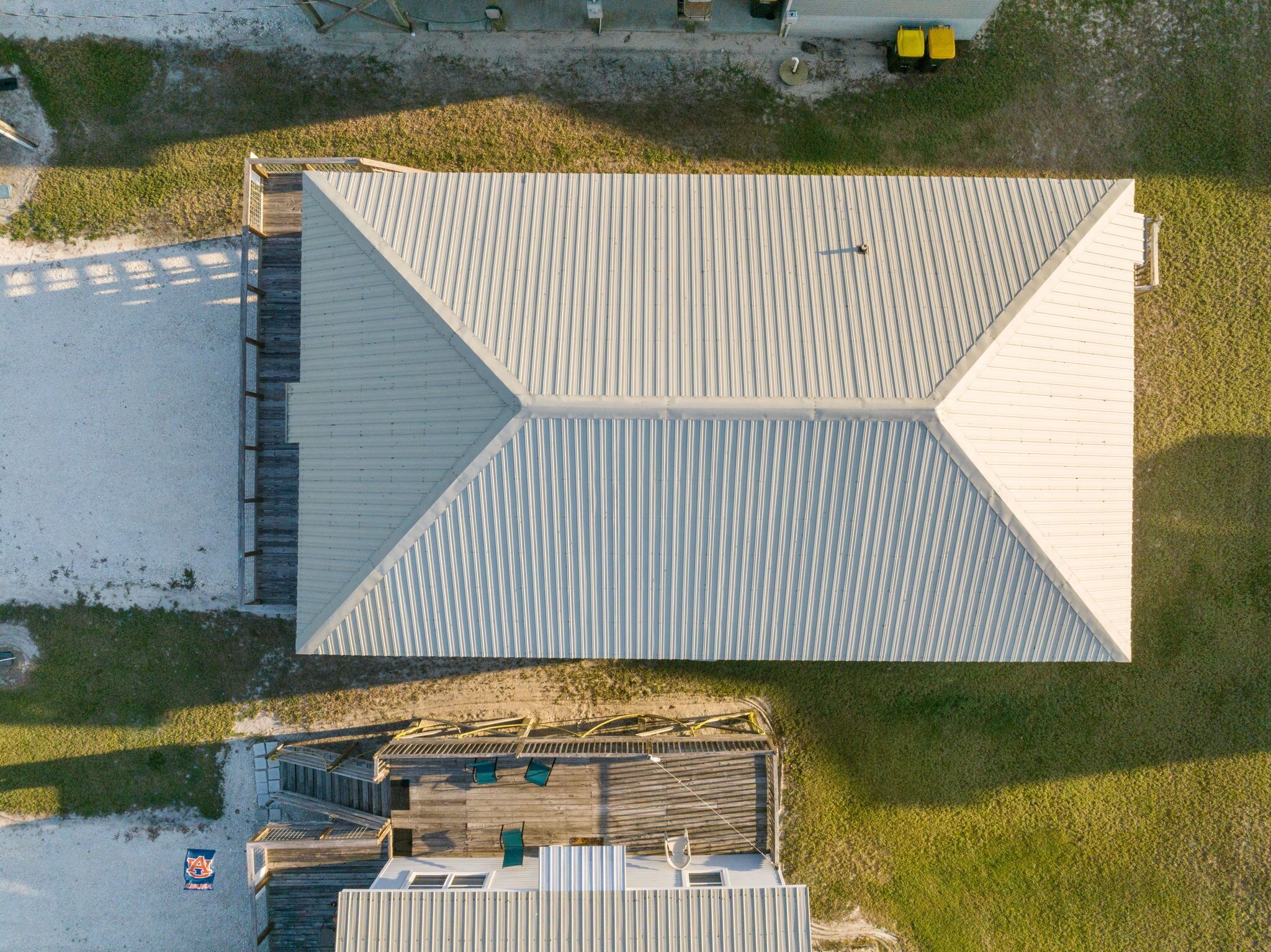 An aerial view of a building with a large, flat roof and a wooden deck area.