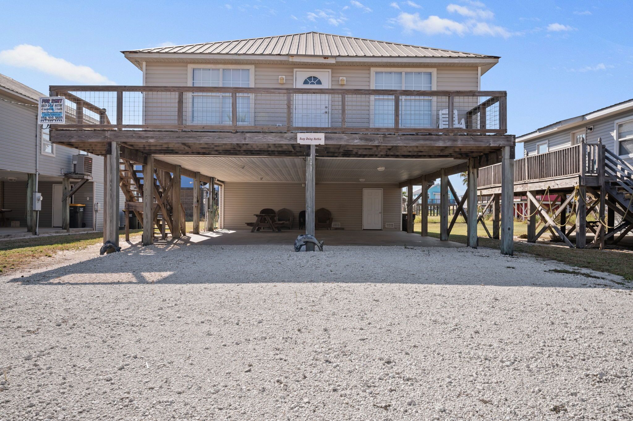 A two-story house with a covered porch and a wooden deck.