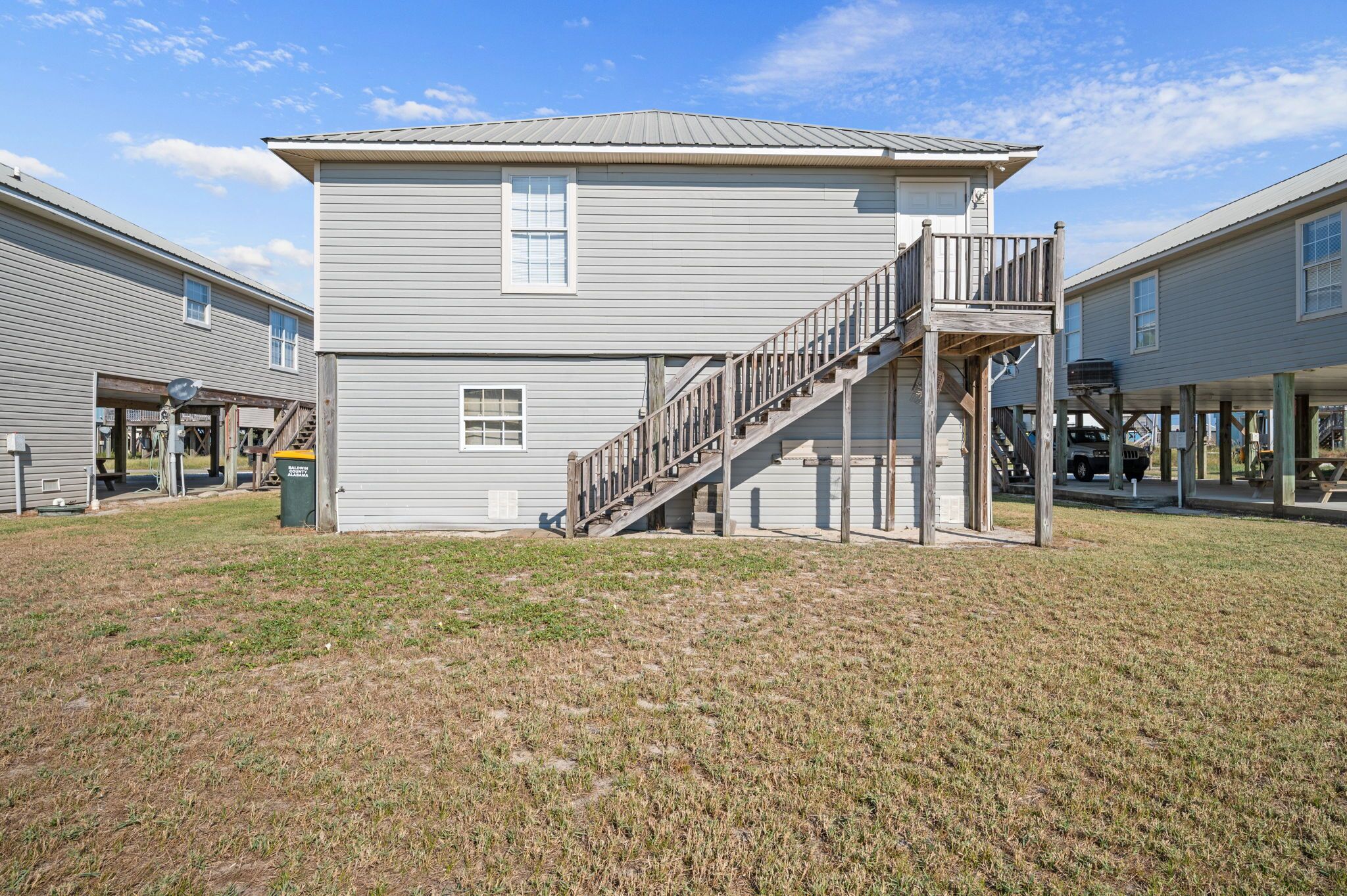 A two-story building with a wooden staircase leading to a balcony.