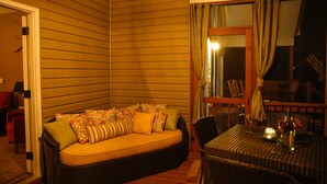 A cozy room with a sofa, a dining table, and a window with curtains. - Private Lakeside, private Dock, Outddor Kitchen Fire Pit & More (Chappells)