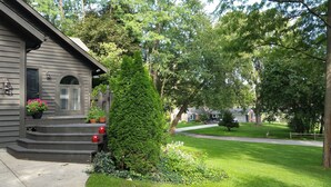 Ein Wohnhaus mit Veranda, Treppen und einem kleinen Garten.