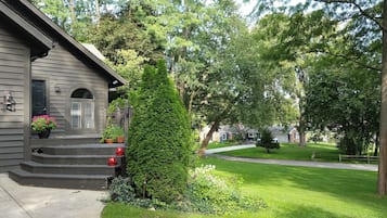 A residential house with a front porch, steps, and a small garden area.