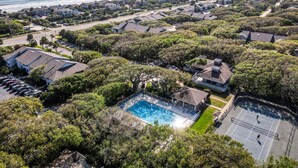 Zona residencial con piscina, casas y vista al océano.