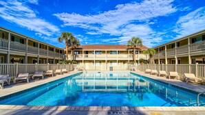 Un hôtel doté d’une piscine, de nombreux balcons et de palmiers.