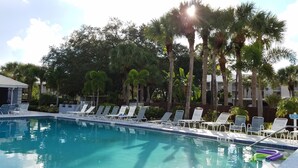 A swimming pool with lounge chairs and palm trees. - Amazing View - On Golf Course - Near Beaches, Shopping & Restaurants (Venice)