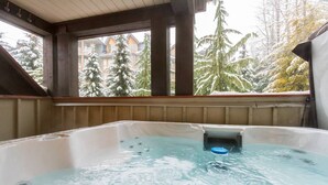 A hot tub with a view of snow-covered trees and buildings. - Private Hot Tub & AC | Pool | Free Parking | Steps to Village, Lifts & Bike Park (Whistler)