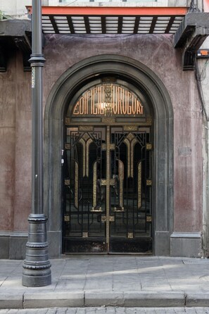 A building entrance with a large, ornate black metal gate and the name "EDIFICIO URUGUAY" above it.