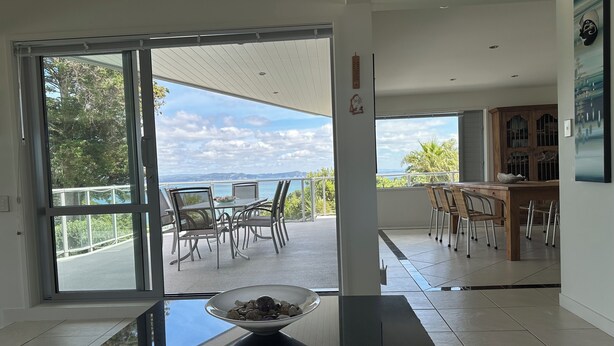 Un intérieur moderne avec une porte vitrée donnant sur un balcon qui offre une vue panoramique.