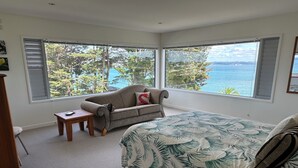 Une chambre avec un grand lit, un canapé et une vue sur la mer.