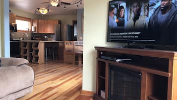 Televisión de pantalla plana, chimenea, libros y biblioteca musical