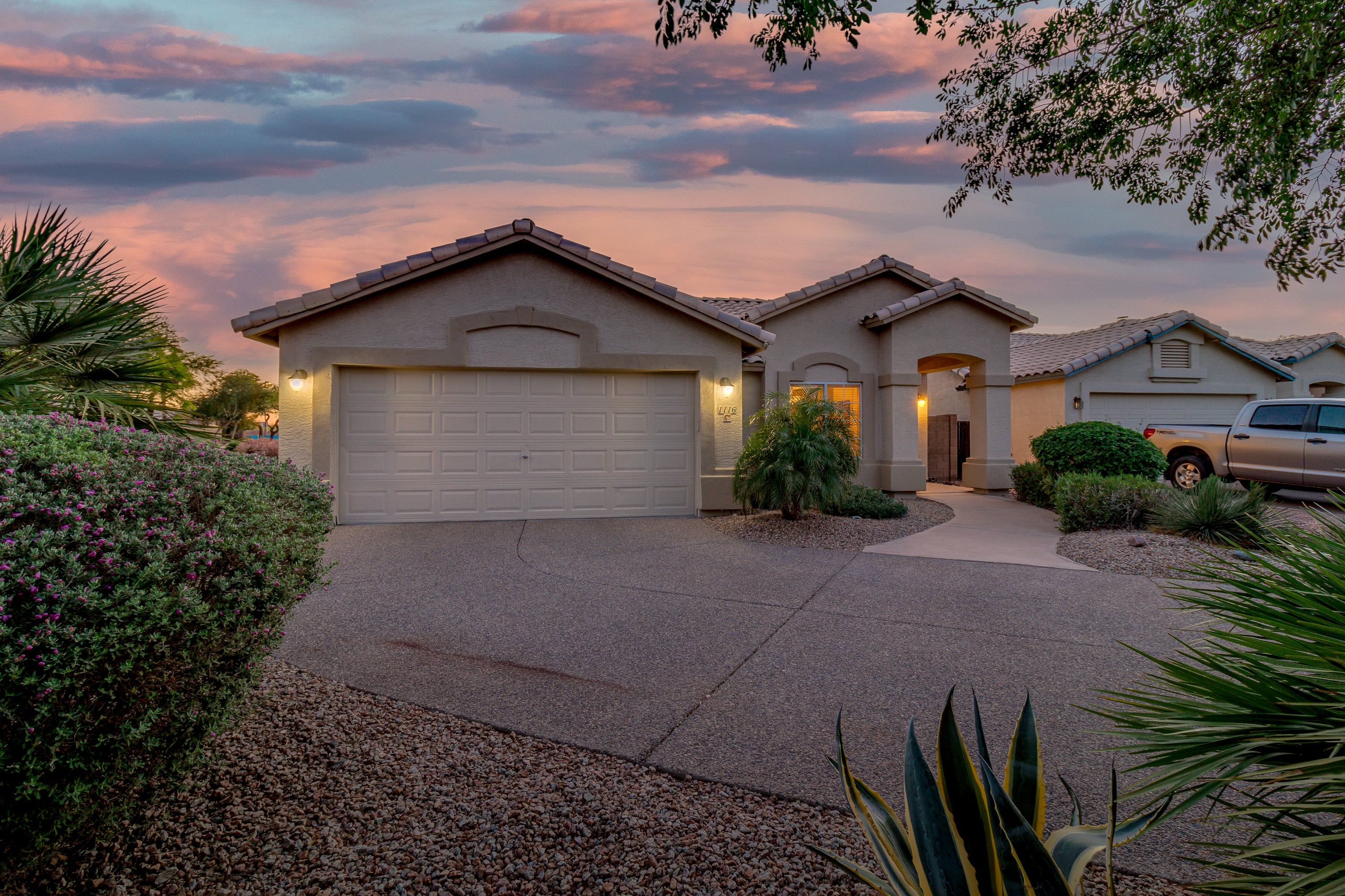 A residential property with a garage, a driveway, and a well-maintained front yard.