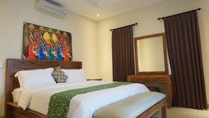 A bedroom with a bed, a bench, a painting, and curtains.