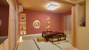 Una habitación japonesa tradicional con suelo de tatami, una mesa de madera baja y un banco de tatami.