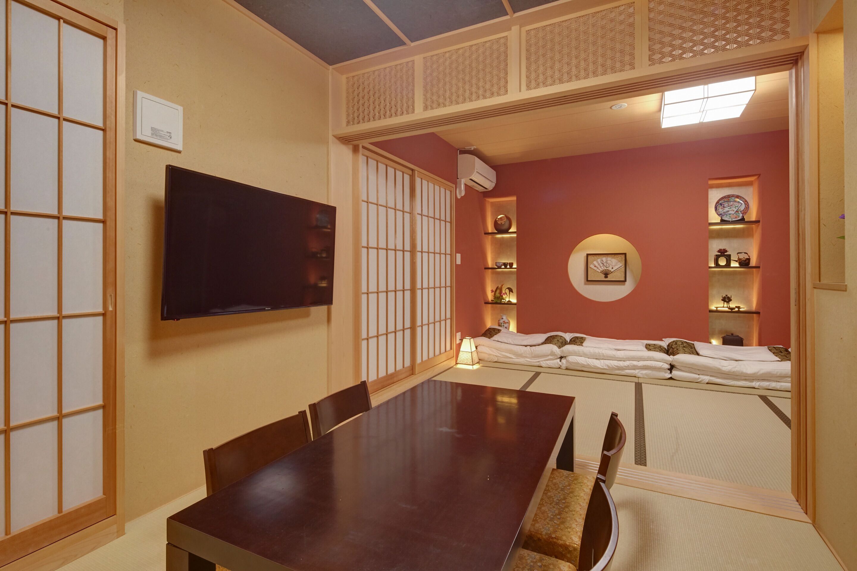 Une pièce de style japonais traditionnel, avec un sol recouvert de tatamis, une table basse et un futon servant de lit.