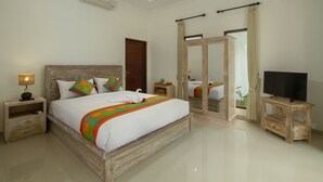 A spacious bedroom with a large bed, wooden headboard, and a television on a wooden stand. - Pondok Ayu Shanti (Ubud)