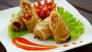 A plate of spring rolls with lettuce and a tomato garnish. - Pondok Ayu Shanti (Ubud)