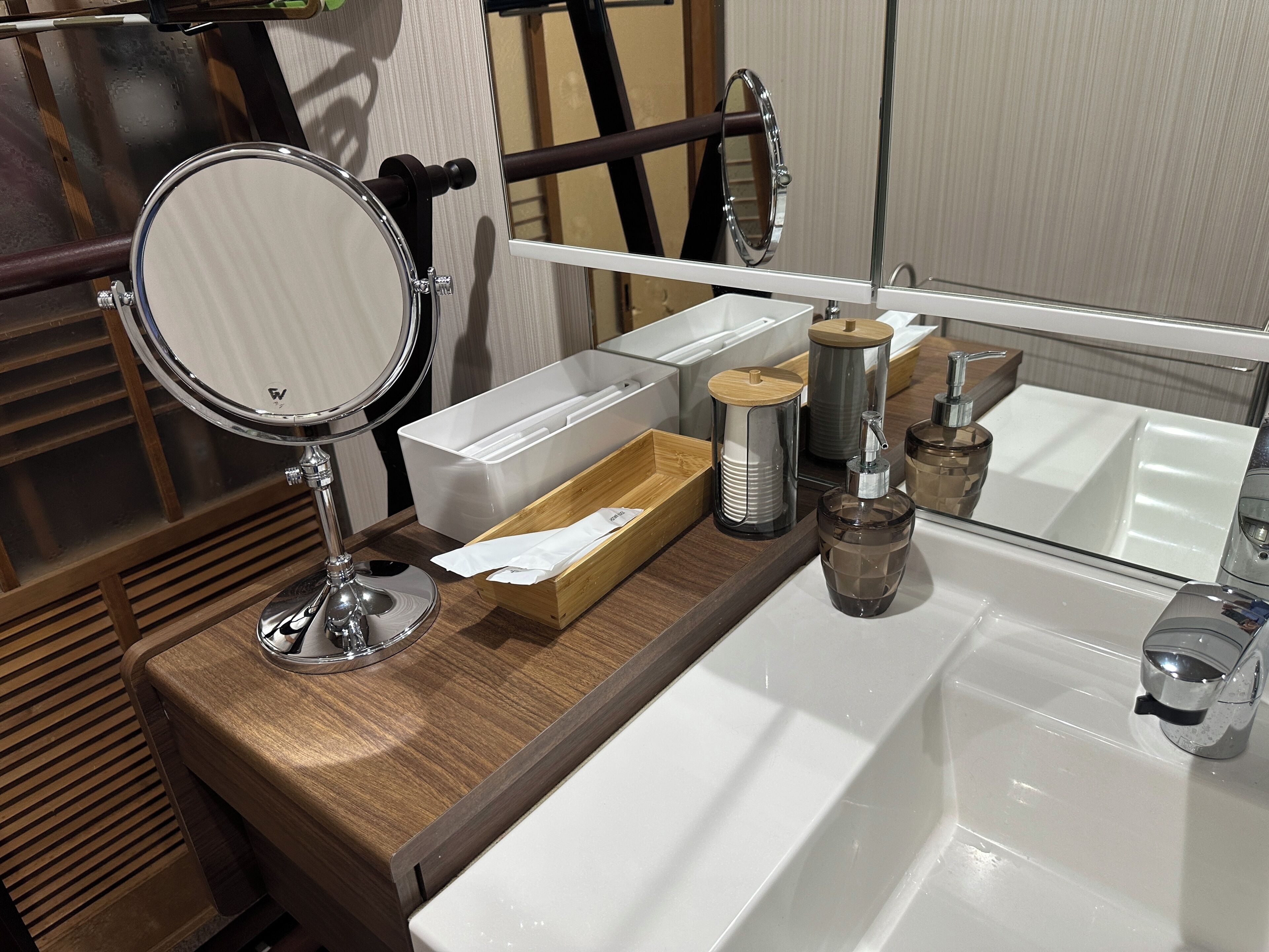 A bathroom vanity with a mirror, a sink, and various toiletries.