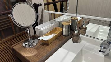 A bathroom vanity with a mirror, a sink, and various toiletries.