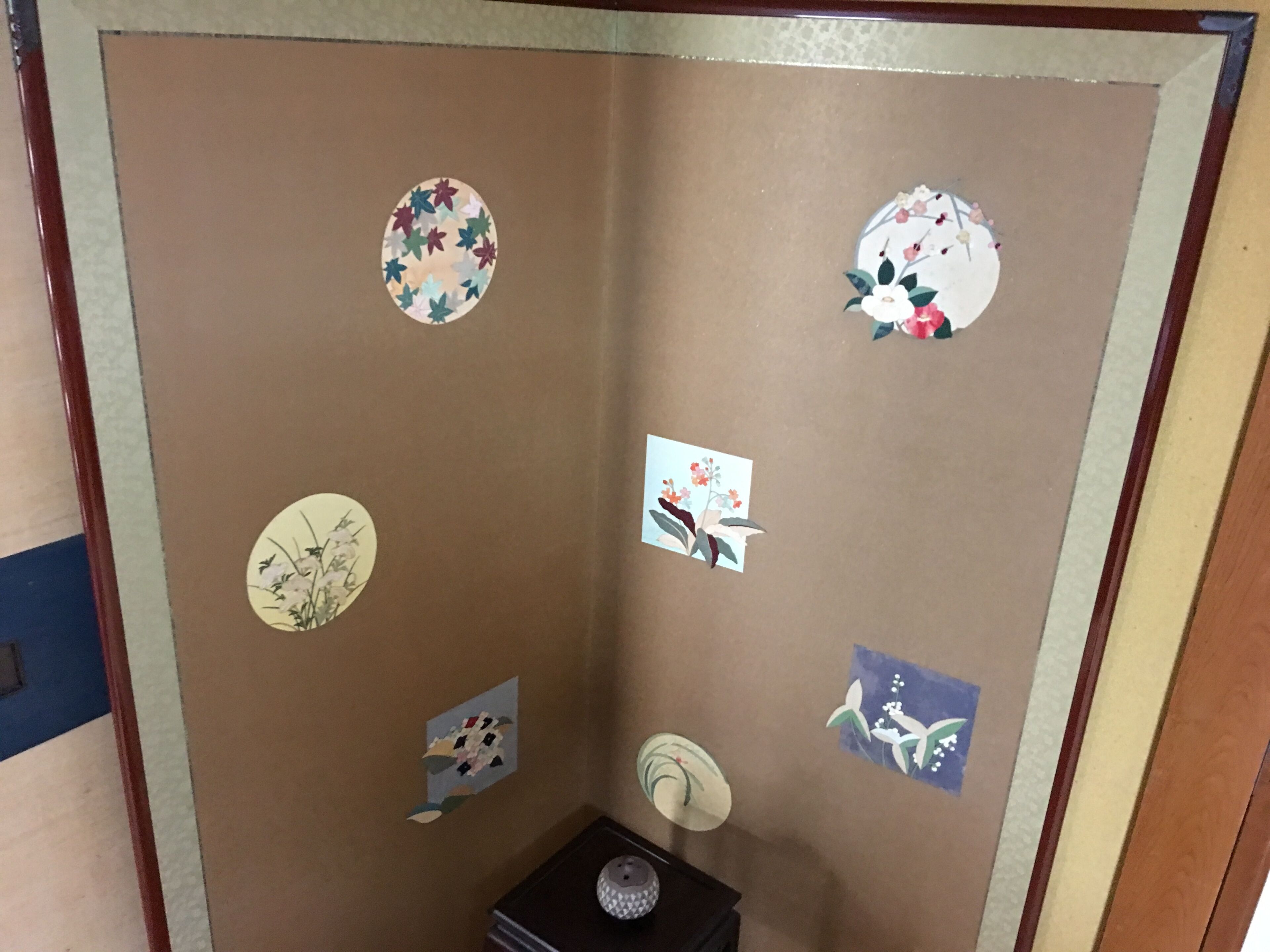 A room with a brown partition featuring multiple circular stickers with floral designs.