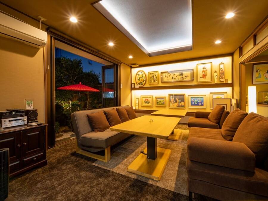 Uma sala de estar moderna com sofá, mesa de centro de madeira e obras de arte penduradas na parede.