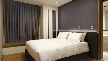 Un dormitorio moderno con una cama grande, una ventana con cortinas y una pared oscura.