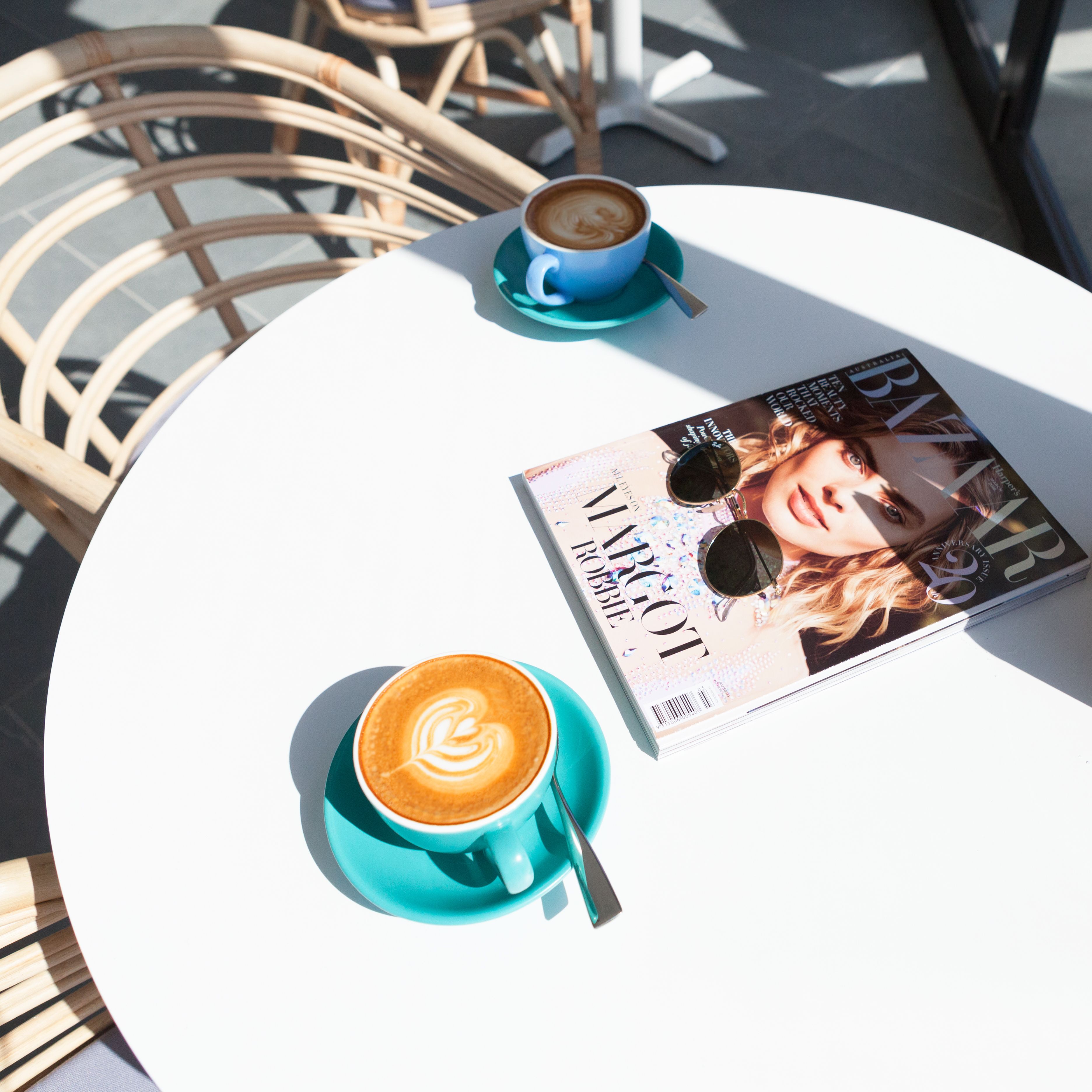Una taula amb una revista, una tassa de cafè i una cadira.