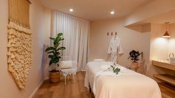 Relax in a serene bedroom with a neatly made bed, a potted plant, and a comfortable chair.