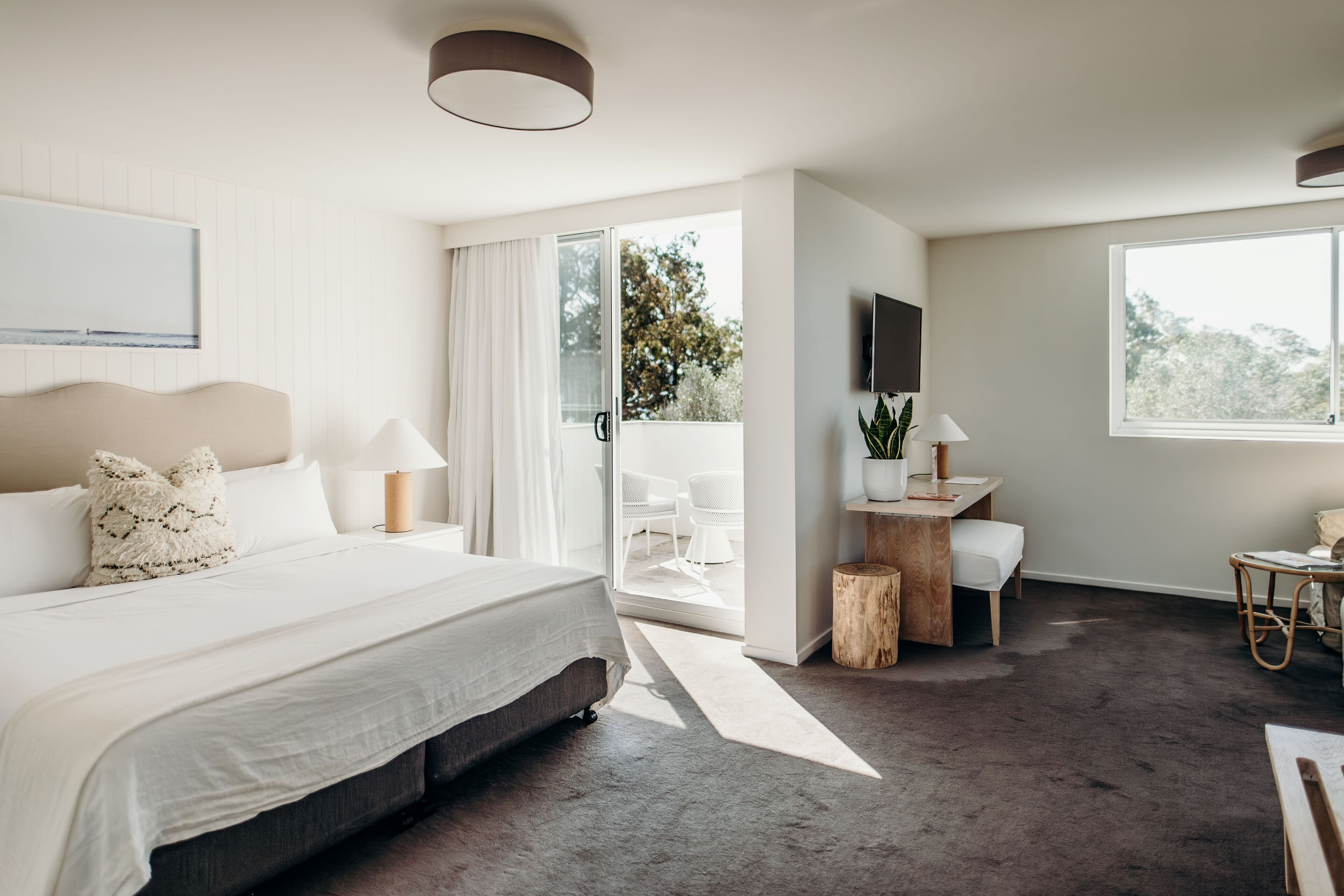 Een moderne slaapkamer met een groot bed, een bureau en een televisie.