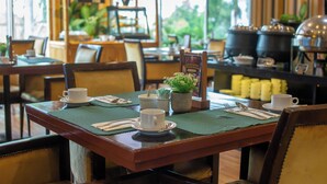 Un restaurante con mesas y sillas de madera, y una zona de bufé.
