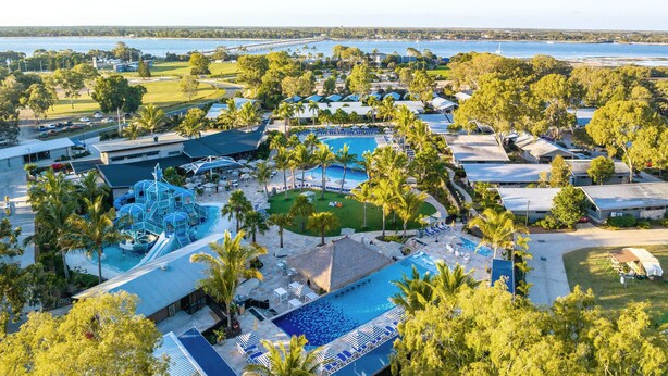 Ein Resort mit mehreren Schwimmbecken, Palmen und Blick auf den Ozean.