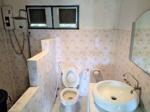 A bathroom with two toilets, a sink, a shower, and a window above the sink. - Mountain Beach  Resort (Rayong)