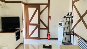 A compact living space with a television, a small table, a sofa, a fire extinguisher, and a ladder. - villageBFH - Hostel (Omura)