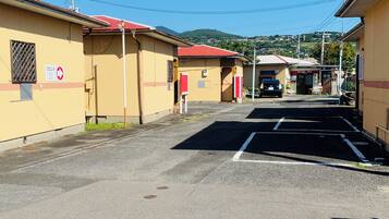 A parking lot with a building on the left and a sign that reads "VILLAGE BPH".