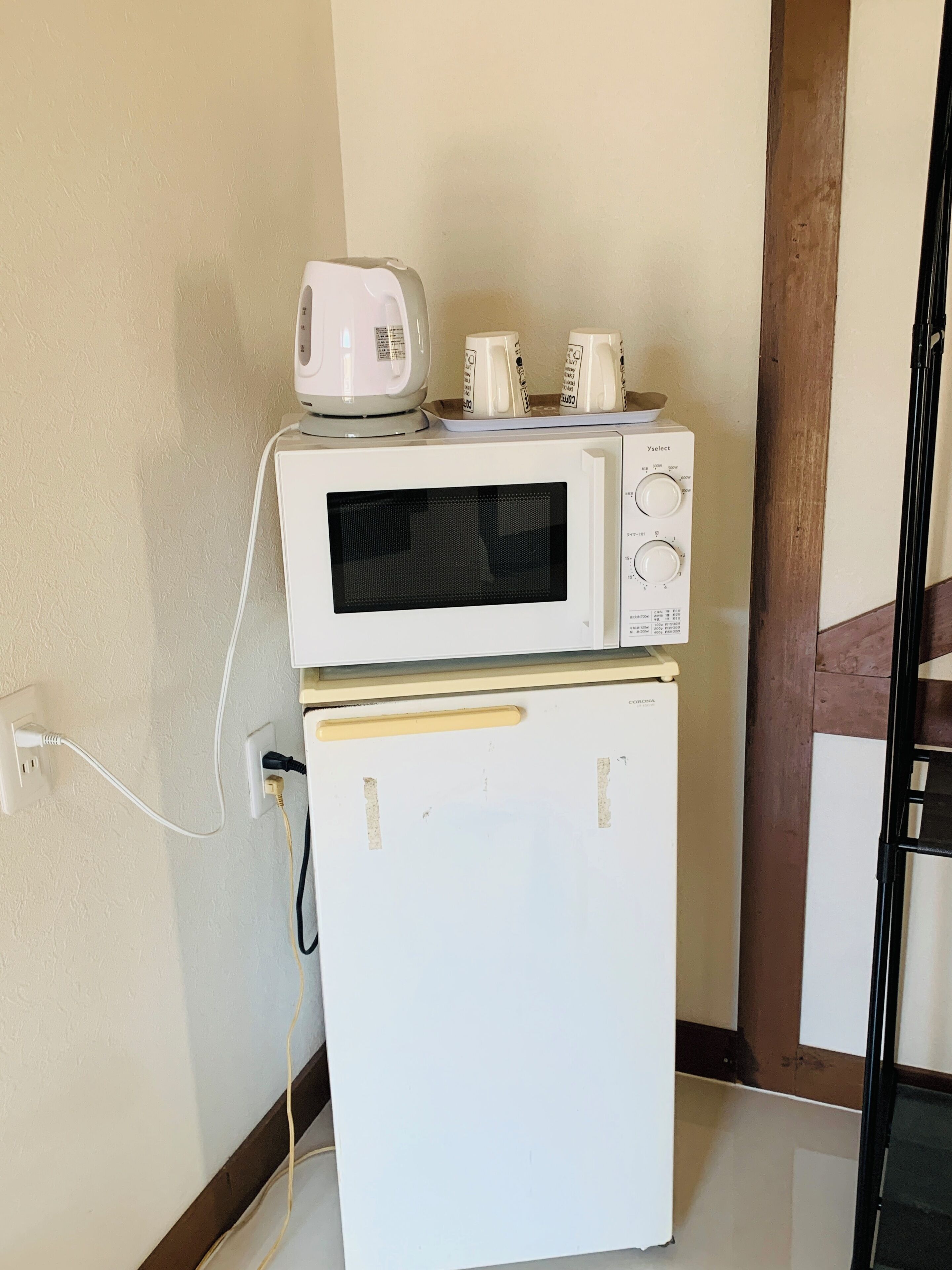 A compact kitchenette with a microwave and a small refrigerator.
