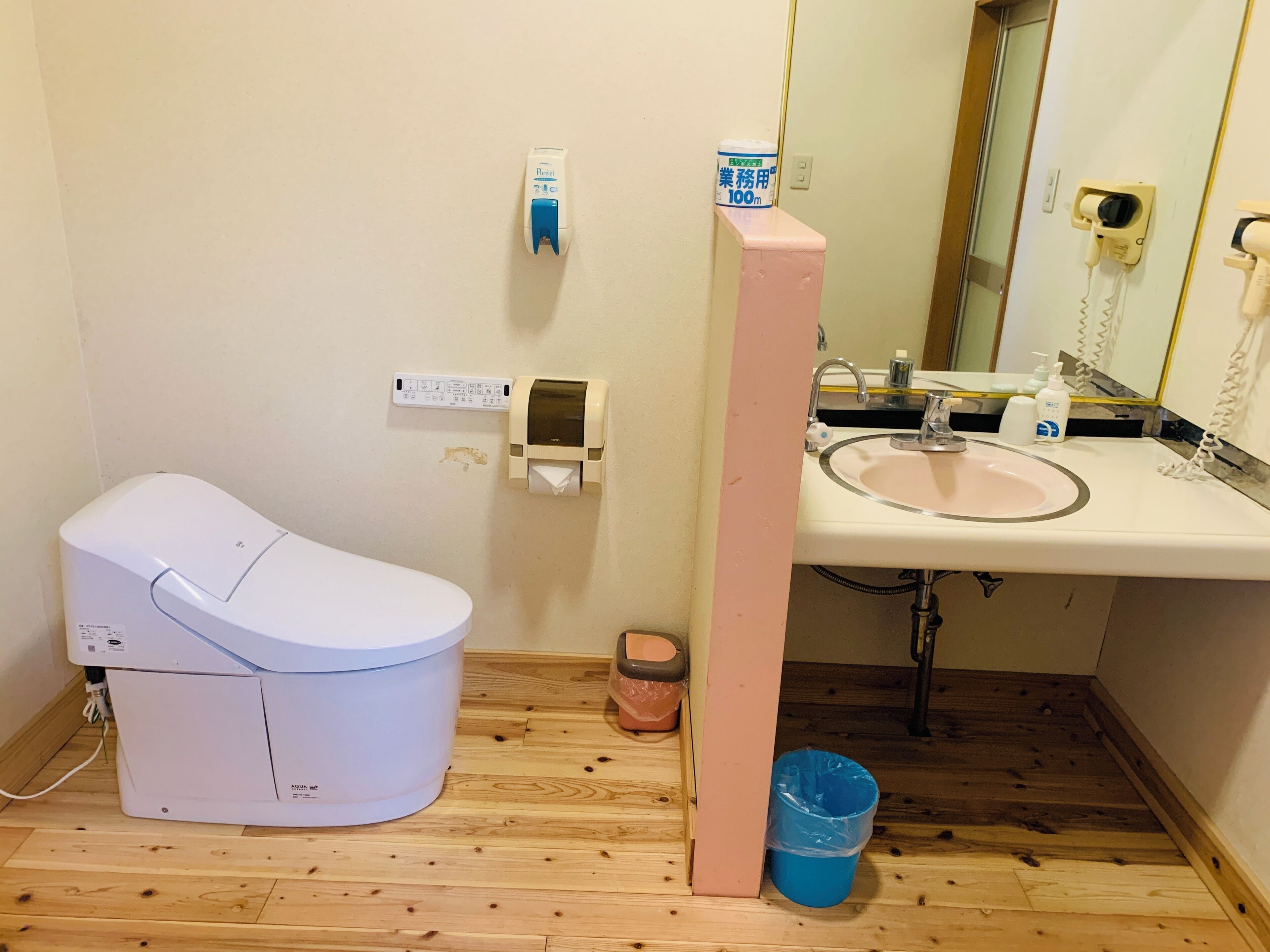 Ein Badezimmer mit Toilette, Waschbecken und Handtrockner.