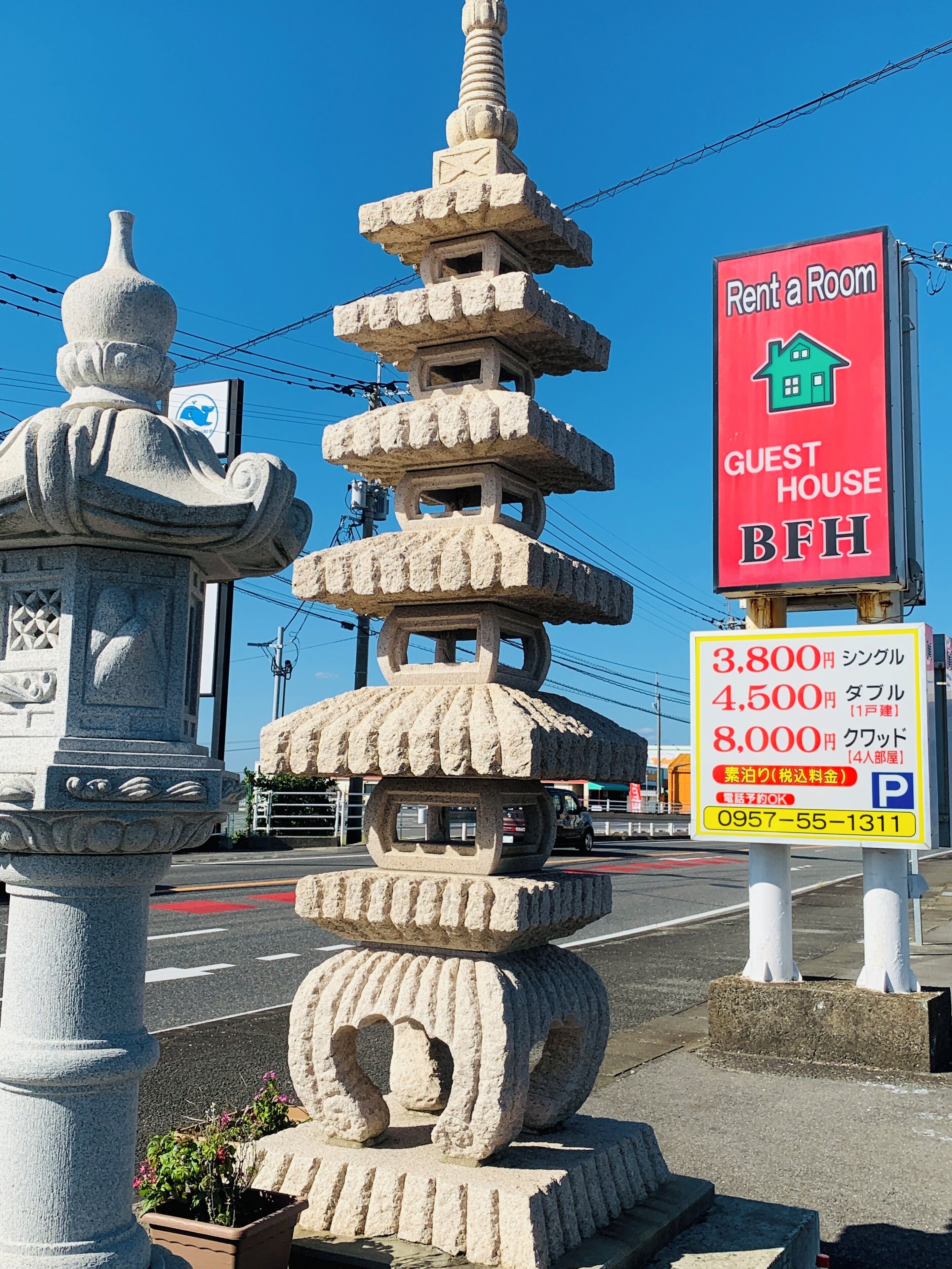 A stone pagoda-like structure with a 'Rent a Room' sign and a 'Guest House BFI' sign nearby.
