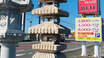 A stone pagoda-like structure with a 'Rent a Room' sign and a 'Guest House BFI' sign nearby.