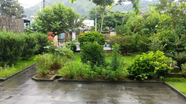 Un jardín con un camino de piedra que lleva a un edificio.