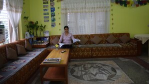 Una sala de estar con un sofá, una mesa de centro y un tapete estampado.
