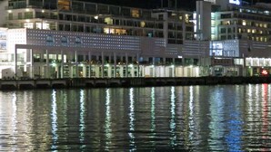 Un edificio moderno con una superficie acuática reflectante al frente.