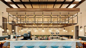 Eine moderne Bar mit einer zentralen Barinsel, Barhocker und hängenden Lampen.