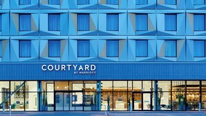 Eine Fassade des Hotels Courtyard by Marriott mit geometrischem Muster, großen Fenstern und modernem Design.
