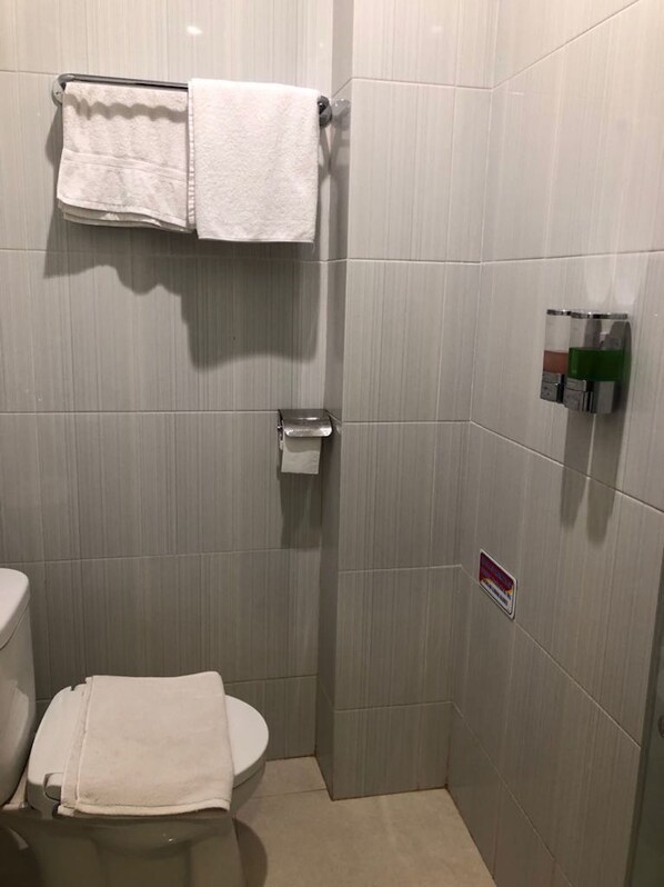A small, modern bathroom with a toilet, a towel rack, and a hand dryer.
