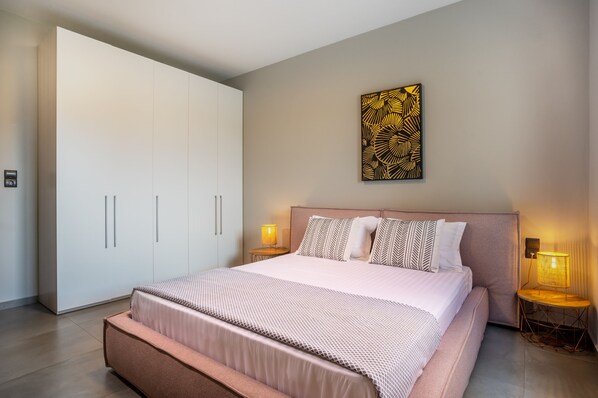 Un dormitorio moderno con una cama grande, un armario y un adorno en la pared.