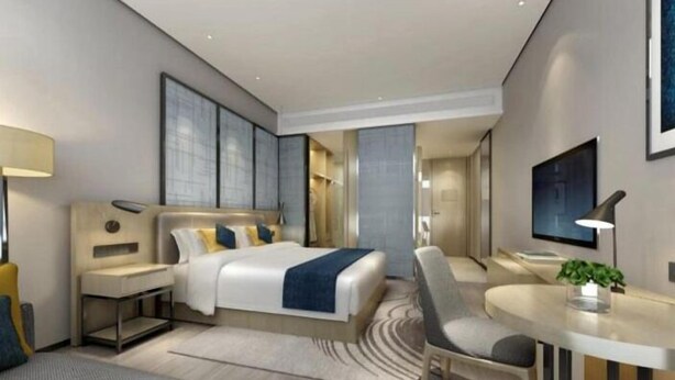 A modern hotel room with a large bed, bedside tables, a desk, and a chair. - Echarm Hotel Kecun Pazhou (Guangzhou)
