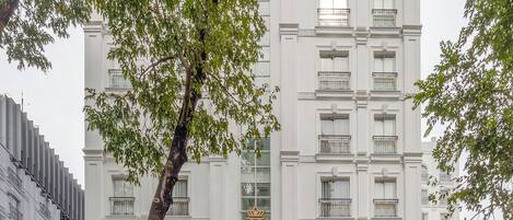 Un hotel y apartamentos T-Ritz con fachada clásica, varios balcones y una entrada imponente.